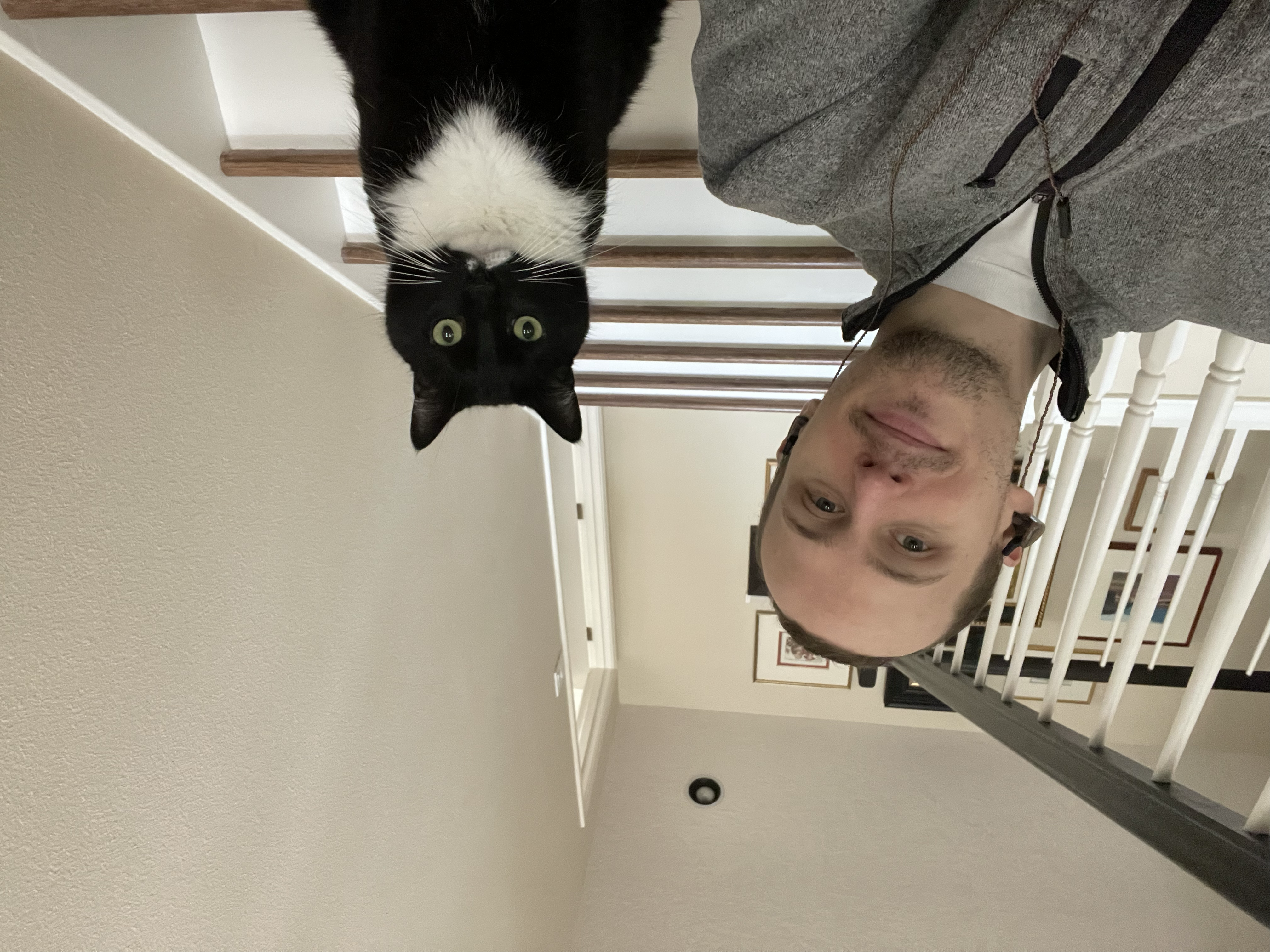 Portrait of Alexander Olivier indoors with his black-and-white cat.